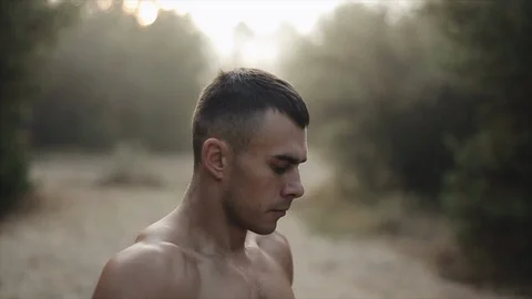 Close up portrait of Young Athletic Guy With Naked Torso Stands In The forest Stock Footage 125854855