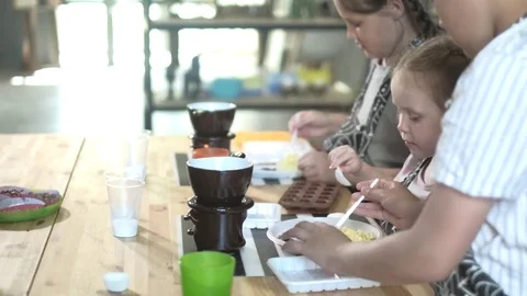 Close up portrait young baker examines and touching using finger chocolate 4k Video stock 77594183
