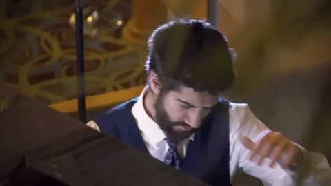Close up portrait of young bearded man playing the piano Stock Footage 105178938