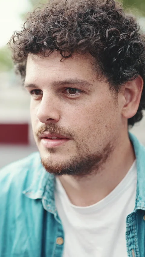 Close-up portrait of young bearded man in denim shirt turning his head and Stock Footage 227005339