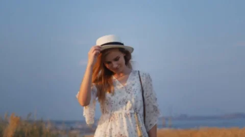 Close up portrait young beautiful smiling woman in white dress  walking on fi 스톡 동영상 112874893