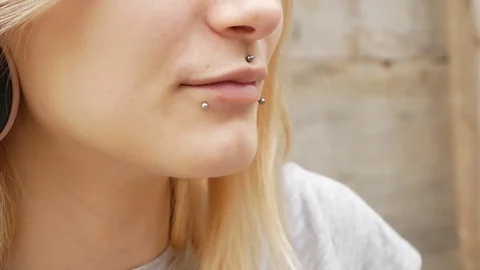 Close-up portrait of a young blonde with a split tongue, she shows a gesture Stock-Footage 80825693