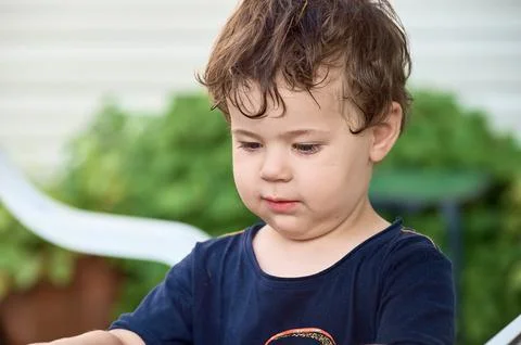 Close up portrait of a young boy exploring the backyard Stock Photos