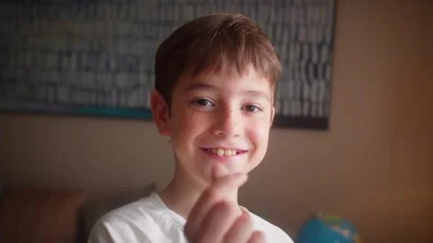 Close up portrait of a young boy smiling and looking at the camera in a cozy Stockbeeldmateriaal 344818411