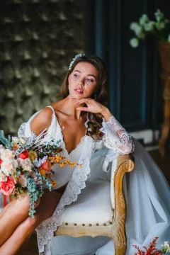 Close-up portrait of young bride posing with gorgeous bridal bouquet on a sofa Stock Photos