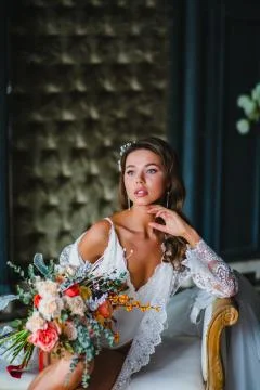 Close-up portrait of young bride posing with gorgeous bridal bouquet on a sofa Stock Photos