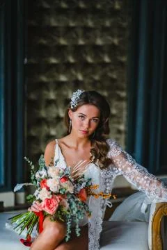 Close-up portrait of young bride posing with gorgeous bridal bouquet on a sofa Foto stock