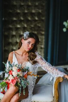 Close-up portrait of young bride posing with gorgeous bridal bouquet on a sofa Stock Photos