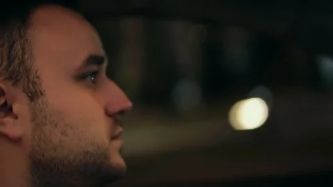 Close-up portrait. a young brutal man in a car driving a car and drinking coffee Stock Footage 129394211