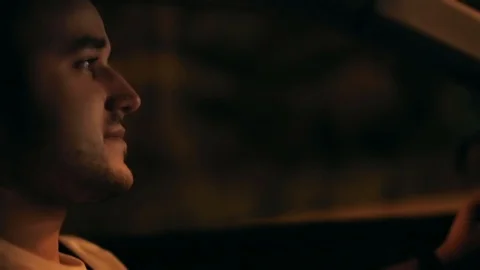 Close-up portrait. young brutal man in a car driving in a car against  Stock Footage 129394305