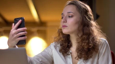 Close-up portrait of young curly-haired businesswoman making selfie-photos using Stock-Footage 101410765