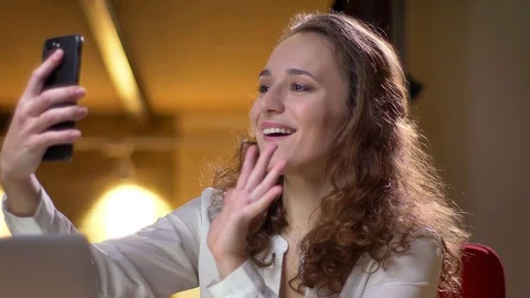 Close-up portrait of young curly-haired businesswoman talking in videochat using Stock Footage 101411201