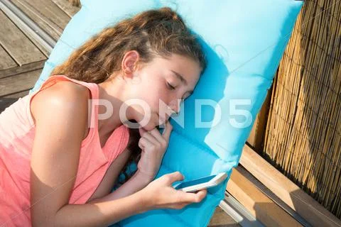 Close up portrait of young girl lying down on deck chair Stock Photos