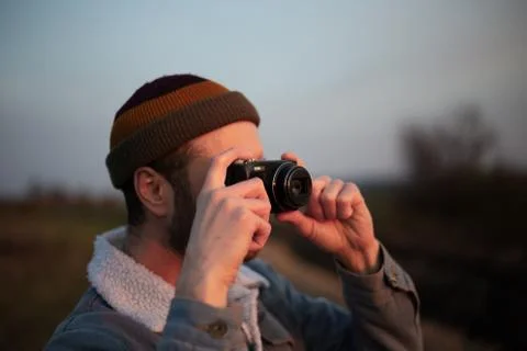 Close-up portrait of young guy taking photo by digital camera. Stock Photos