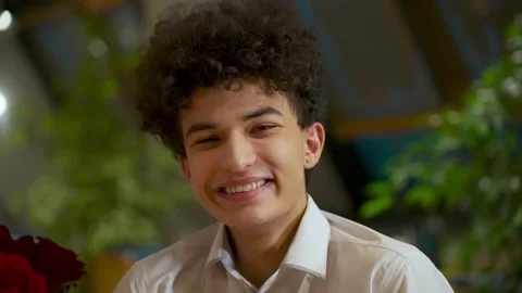 Close-up portrait of a young handsome guy zoomer mixed race with an african Stock Footage 168369371