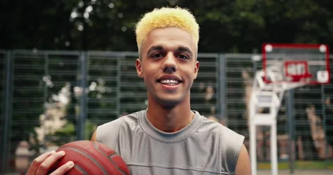 Close up portrait of young happy guy standing on urban basketball court with Stock Footage 139649138