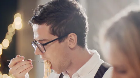Close up portrait of young hipster guy eating at table at party or celebration Stock Footage 181422394