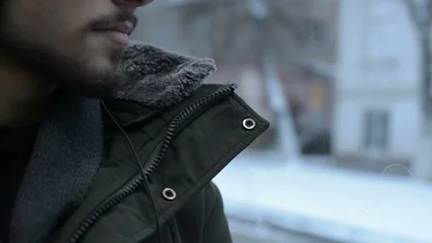 Close up portrait Young long haired bearded man in a jacket and large headphones Stock Footage 101128146