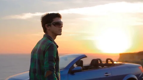 Close up portrait of young man by cabriolet enjoying life, on rock above the sea 스톡 동영상 73936882