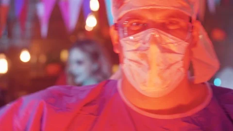 Close-up portrait of a young man dressed in the costume of a mad killer doctor Stock Footage 107907476