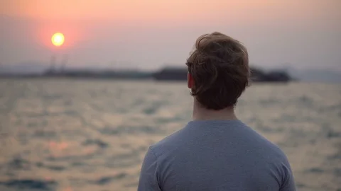 Close up Portrait of Young Man Looking at Beautiful Sunset Over Ocean Stock Footage 126259112