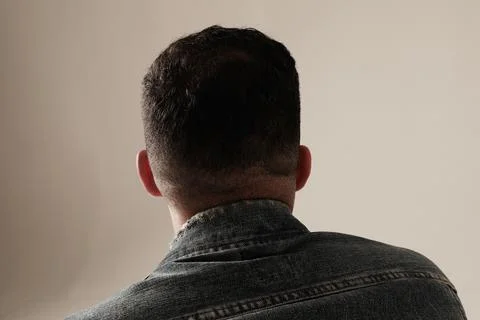 Close-up portrait of young man posing and sitting indoor. Mock-up. Backview. 写真素材