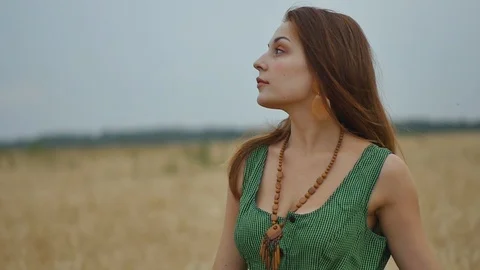 Close-up portrait. Young red-haired woman in a green dress in an evening wheat Stock Footage 115171058