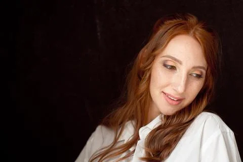 Close up portrait of young red-haired woman on black background Stock Photos