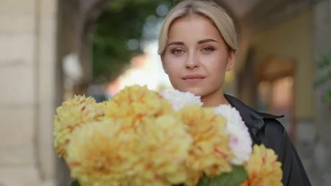 Close up portrait of a young  smiling cute girl with a huge bouquet of flowers Video stock 234104145