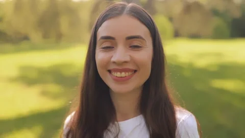 Close-up portrait of young smiling long-haired woman, girl, lady outdoors Video stock 275341058