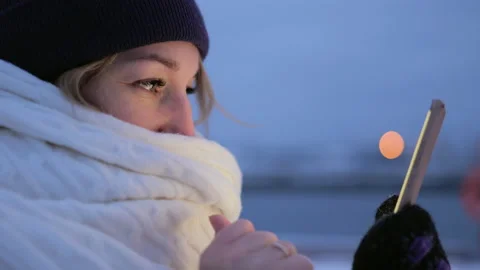 Close-up portrait of young woman uses mobile phone outdoors Stock Footage 233216853