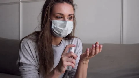 Close up portrait of young woman using hand sanitizer spray during pandemic l Stock Footage 134420182