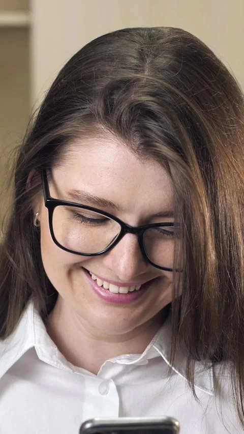 Close-up portrait of a young woman using a smartphone for messages in the office Stock Footage 299625193