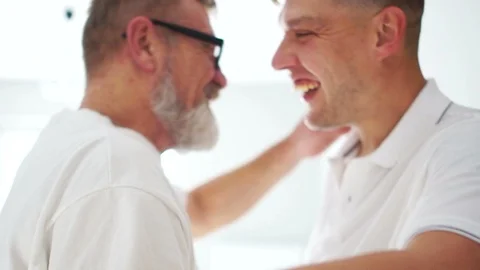 Close portraits of two hugging men - an elderly father and an adult son. Men are Stock Footage 120639732
