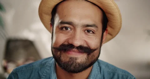 Close up of positive Hispanic man touching his mustache and smiling to camera Stock Footage 120744190