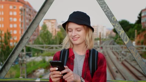 Close up of positive young female using smartphone at bridge with railways on Stock Footage 115910556