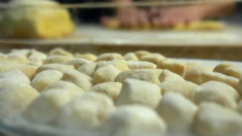 Close up potato dumplings with blurred background woman kneading. Video stock 151154968