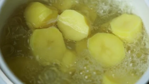 Close-up of potatoes boiling in water in a white saucepan. The concept of mashed Stock Footage 317141702
