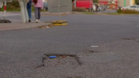 Close-up pothole with blue plastic cap in urban intersection Stock Footage 347204415