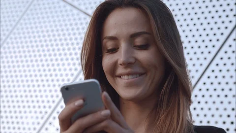 Close-up potrait happy and in love girl typing in the phone and smile Stock Footage 97625853