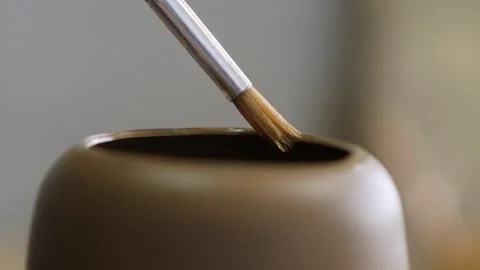 Close-up. the potter brushes the top of the product with a brush for its furt Stock Footage 144244899