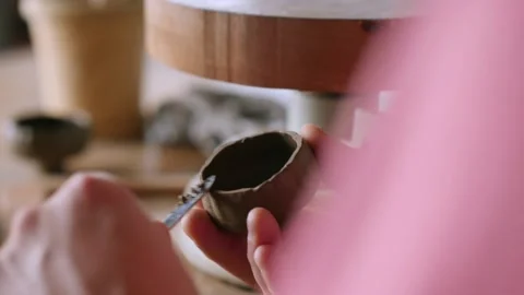 Close-up.a potter cuts off the remnants of clay from a clay bowl with a knife Stock Footage 145534974