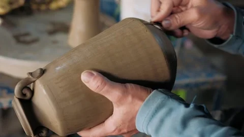 Close up of a potter hands to shape and refine a clay vase. Handmade concept Stock Footage 325973863