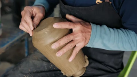Close up of a potter hands to shape and refine a clay vase. Handmade concept Stock Footage 325973892