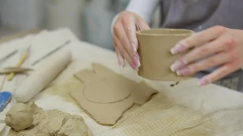 Close-up of a potter hands shaping a clay mug with precision in a traditional Stock Footage 302547406