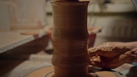 Close up potter makes a pot on the spinning pottery wheel. Professional Stock Footage 267693203