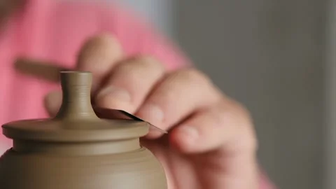 Close-up. potter shaping the lid of the clay teapot on the potter's whee Stock Footage 145543894