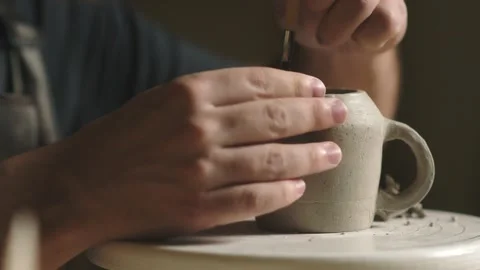 Close up of potter using tools to making ceramic clay cup in potter studio Stock Footage 143617154