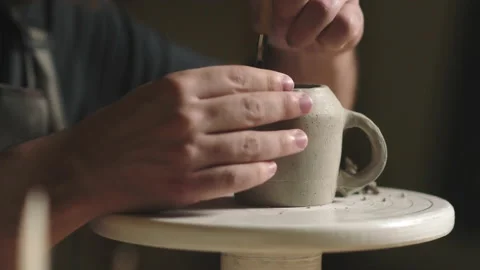 Close up of potter using tools to making ceramic clay cup in potter studio Stock Footage 184246498