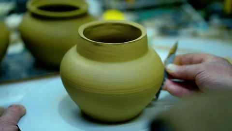 Close-up of a potter's hand using a metal trimming tool. Stock Footage 328925362